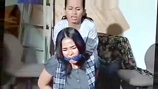 Zwei asiatische Frauen dominieren und verwöhnen sich in einer BDSM-Begegnung.
